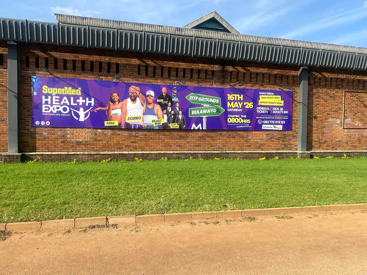 SuperMed Health Expo banner installed on an exterior brick wall